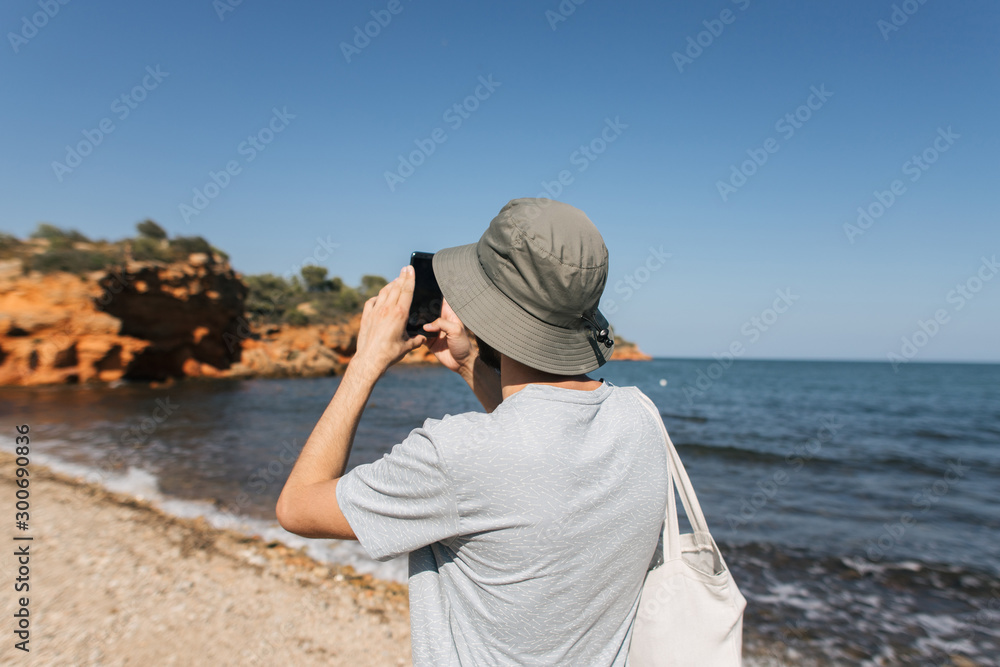 man in panama taking photo at sea