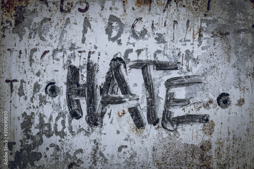 Hate written/painted on concrete wall. Texture, message, quote, statement concept. photo