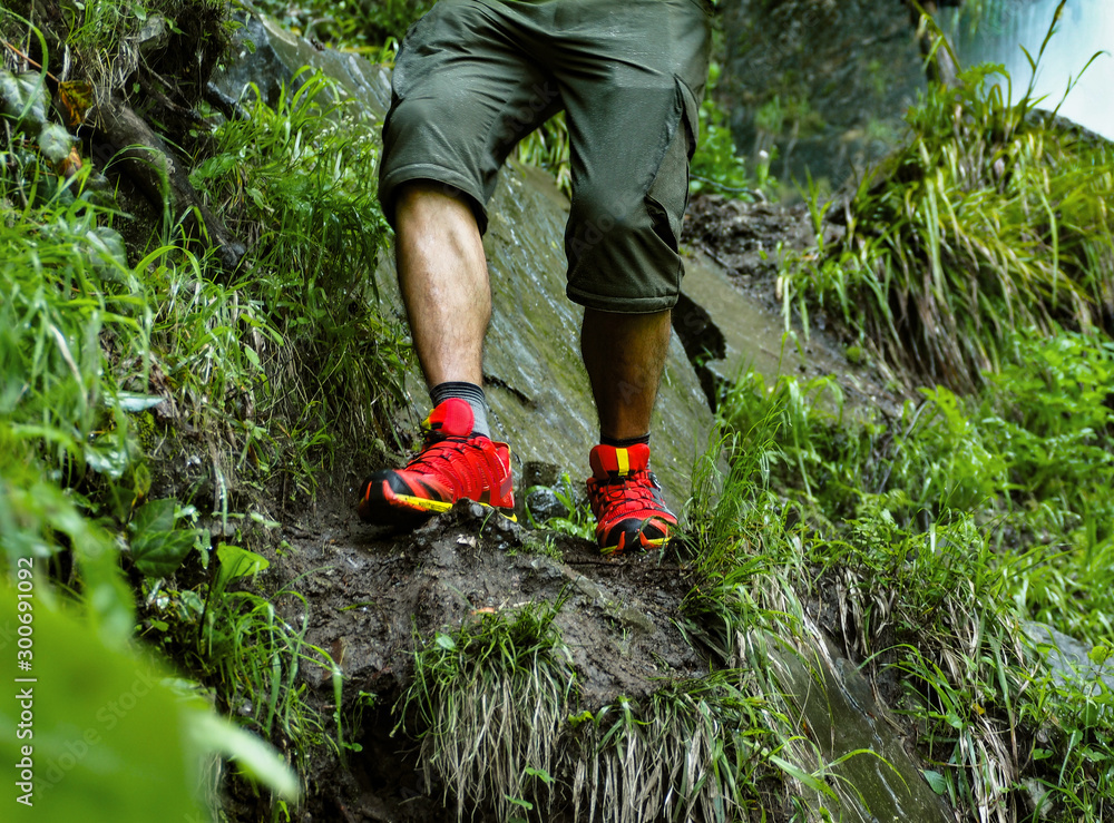 Fototapeta premium Active man with trekking boots walking on rocky and dirty path