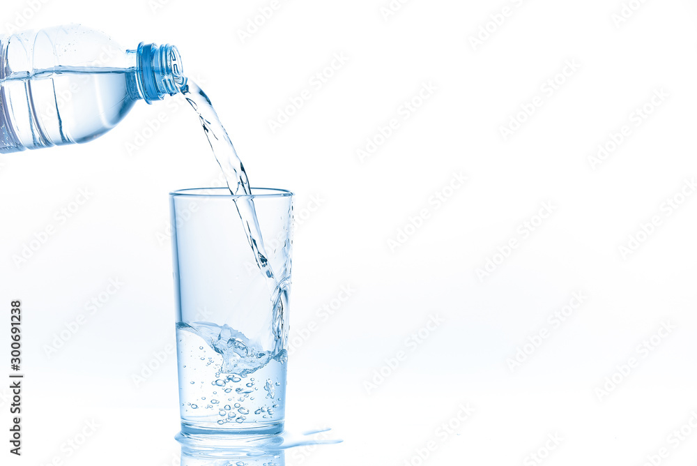 Pouring water from bottle into glass on white background. Photo with copy space. Pouring water from bottle into glass on white background. Photo with copy space.