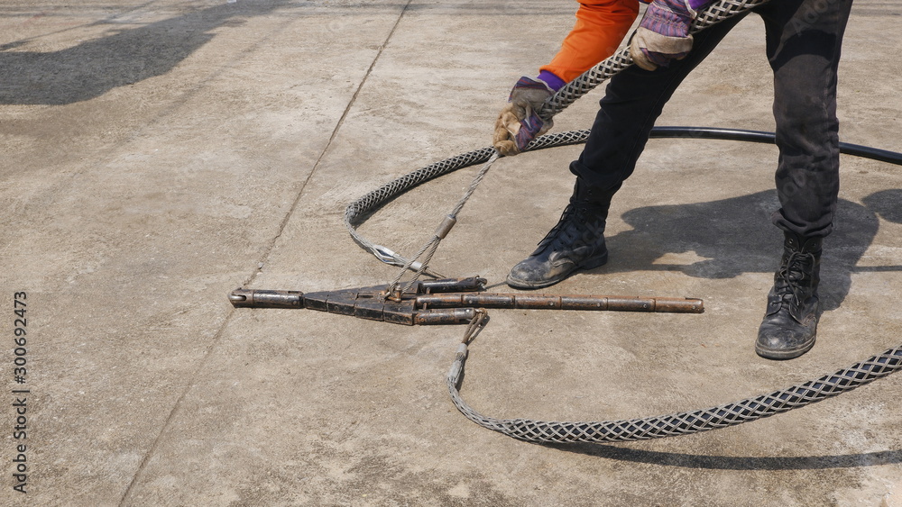 Part of electrician holding stainless steel slack grip for pulling
