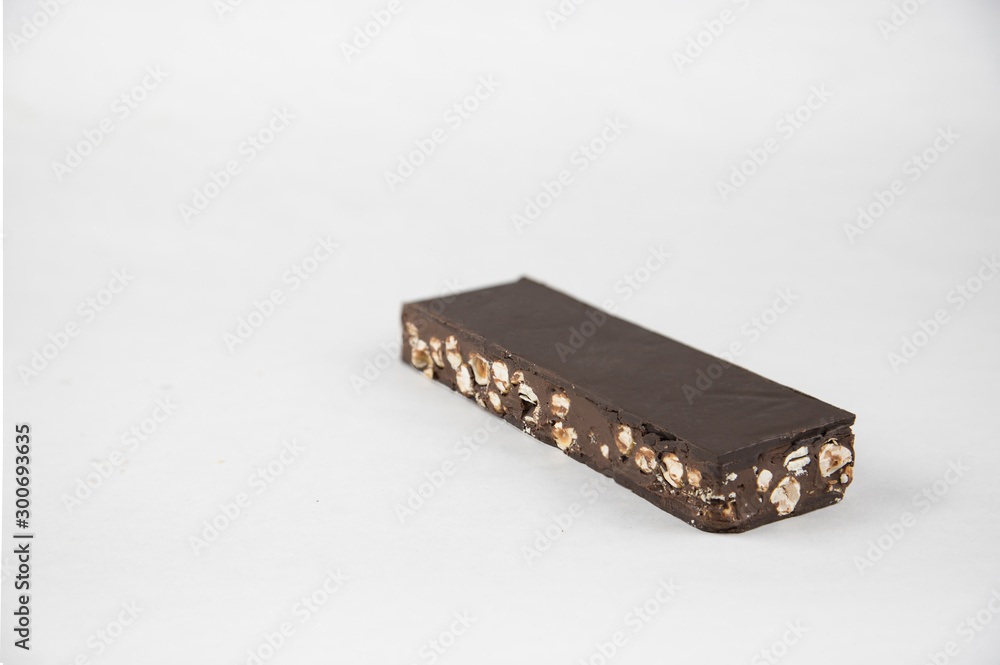 Chocolate and hazelnut nougat on a white background. Copy space. Sweet Christmas. - Image Chocolate and hazelnut nougat on a white background. Copy space. Sweet Christmas. - Image