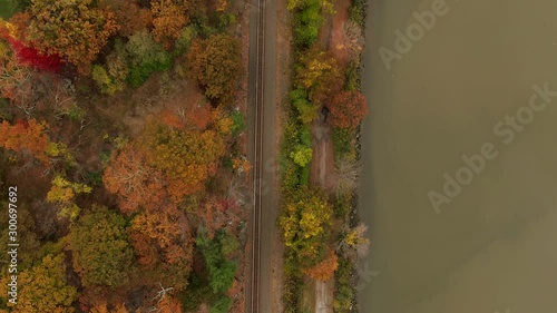 Top down aerial over train tracks autumn foliage reveal Bear Mountain Bridge on Hudson River photo