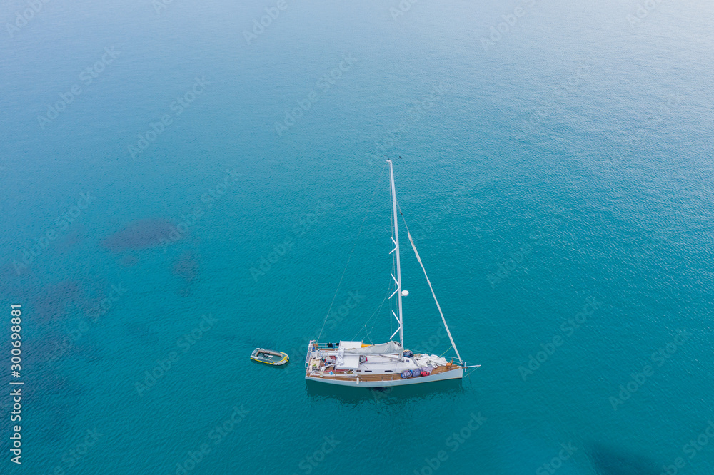 Fototapeta premium Aerial view of white Yacht in deep blue sea with beautiful landscape view in Kudat, Sabah, Borneo