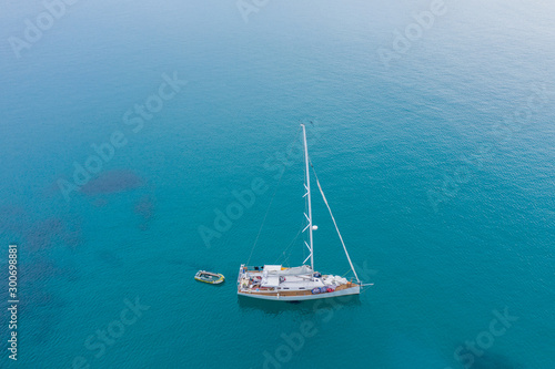 Aerial view of white Yacht in deep blue sea with beautiful landscape view in Kudat, Sabah, Borneo