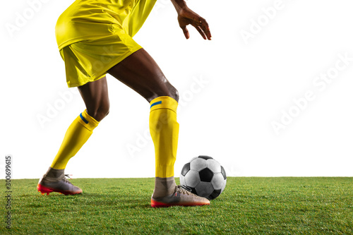 Professional african-american football or soccer player of yellow team in motion isolated on white studio background. Fit man in action, excitement, emotional moment. Concept of movement at gameplay. © master1305