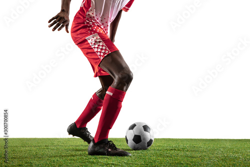 Professional african-american football or soccer player of red team in motion isolated on white studio background. Fit man in action, excitement, emotional moment. Concept of movement at gameplay. © master1305