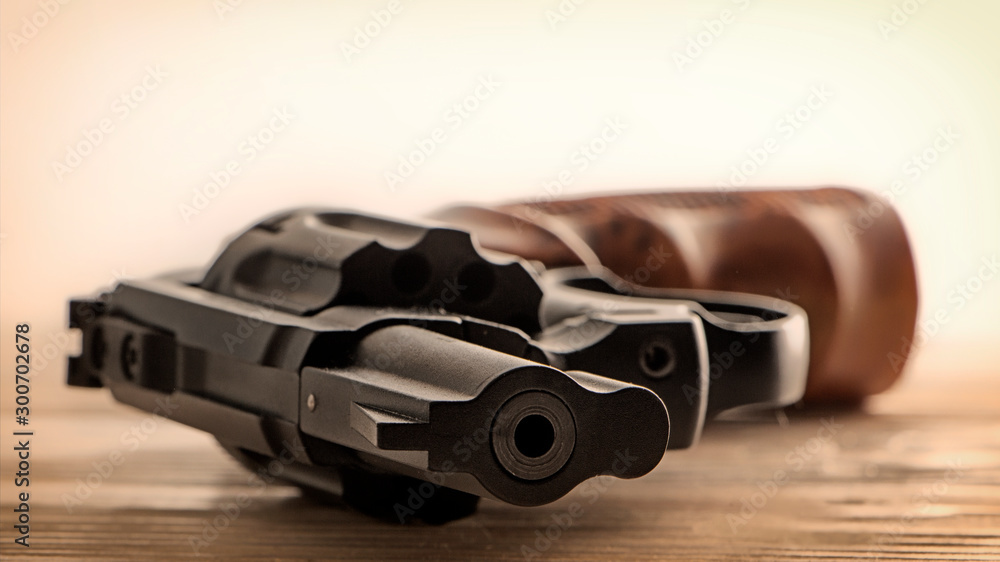Obraz premium Black revolver front view lying on wooden surface