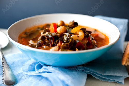 Close up of chard and chickpea minestrone soup served in bowl