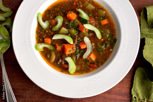 Tomato minestrone soup garnished with celery served in bowl