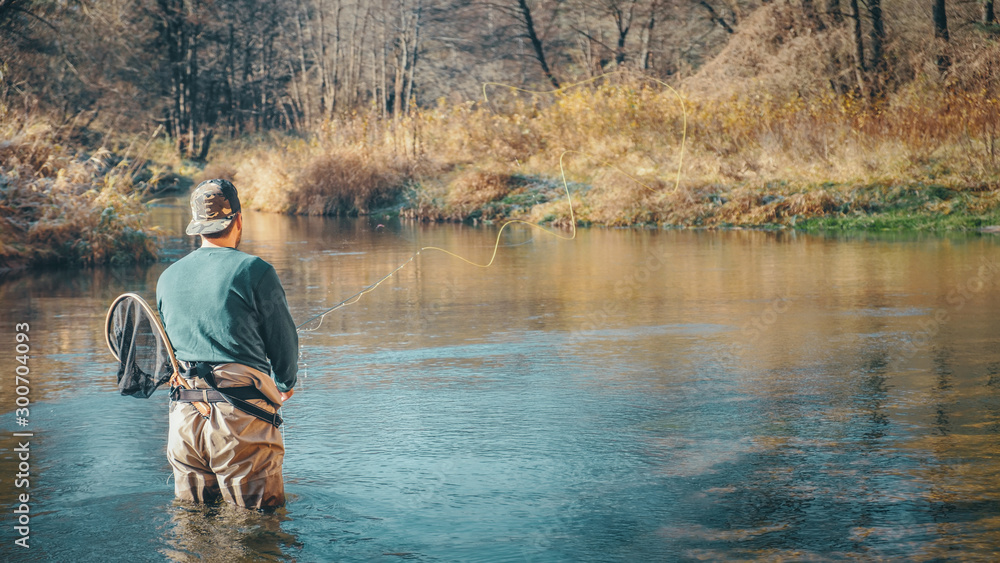 Fly fishing on a forest river background