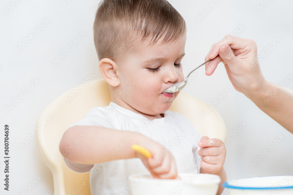 mom feeds her little baby with a spoon mom feeds her little baby with a spoon