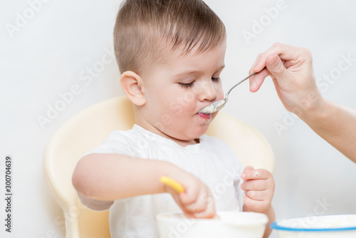 mom feeds her little baby with a spoon