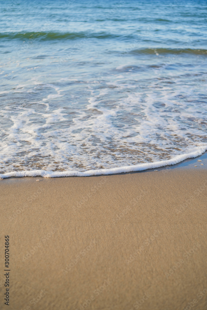 azure waves roll onto the sand of a beach on a sunny day, wallpapers for mobile devices