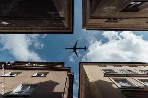 Passenger plane flying over the roofs of residential homes, low airplane flies, transportation