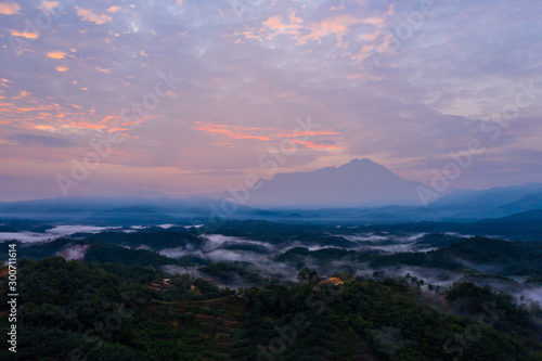 Aerial drone image of Beautiful harmony romantic color sunrise landscape scenery with sunlight and fog and Mount Kinabalu as background in Guakon, Sabah, Malaysia photo