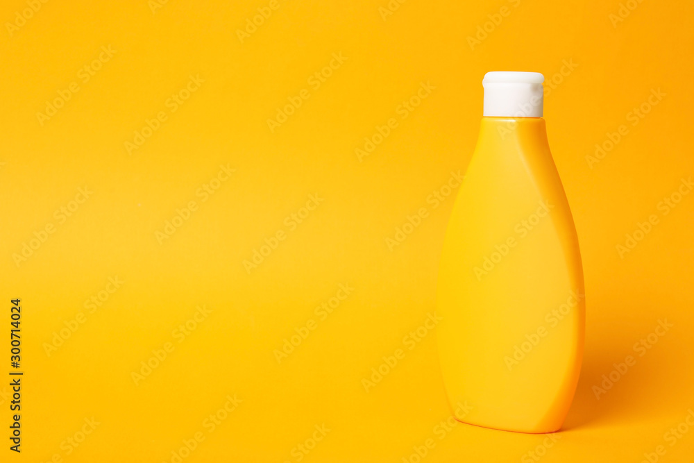 Bottle of shampoo on orange background, space for text. Natural cosmetic products Bottle of shampoo on orange background, space for text. Natural cosmetic products