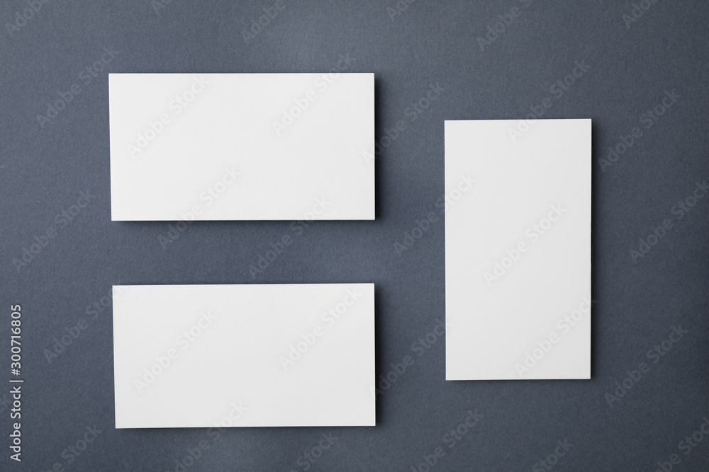 Blank business cards on dark grey background, flat lay. Mock up for design Blank business cards on dark grey background, flat lay. Mock up for design