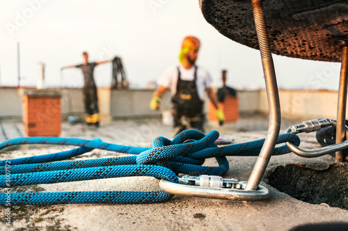 Industrial rope access worker hanging from the building while painting the exterior facade wall. Industrial alpinism concept image. Top view