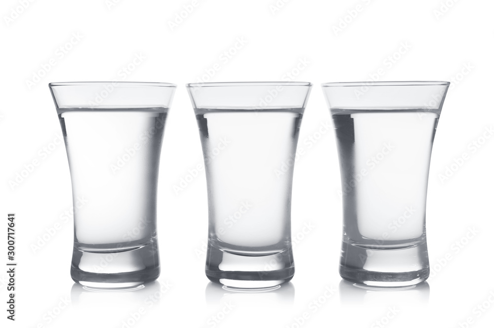 Cold vodka in shot glasses on white background Cold vodka in shot glasses on white background