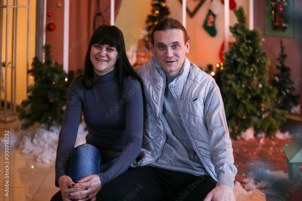 Obraz premium adult brother and sister in Christmas decorations smiling and hugging