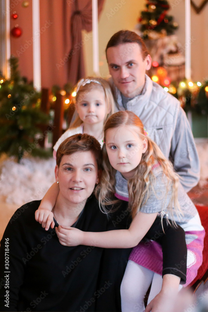 family in christmas decorations smiling and hugging family in christmas decorations smiling and hugging