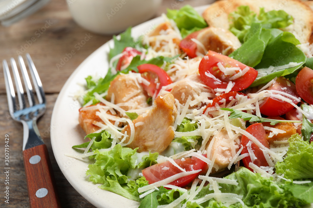 Delicious fresh Caesar salad on wooden table, closeup Delicious fresh Caesar salad on wooden table, closeup