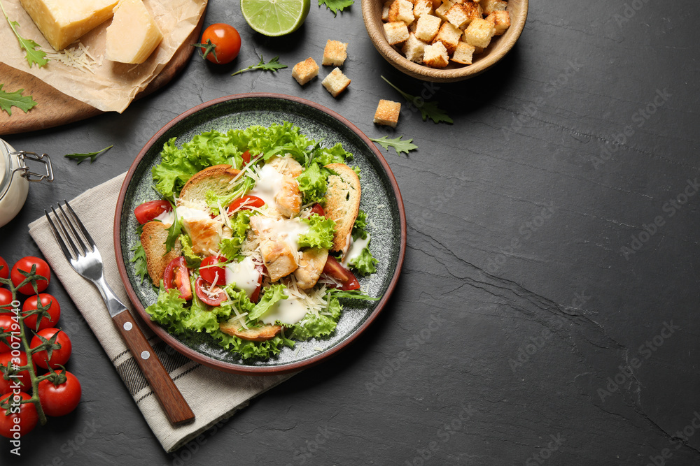 Delicious fresh Caesar salad on black table, flat lay. Space for text Delicious fresh Caesar salad on black table, flat lay. Space for text