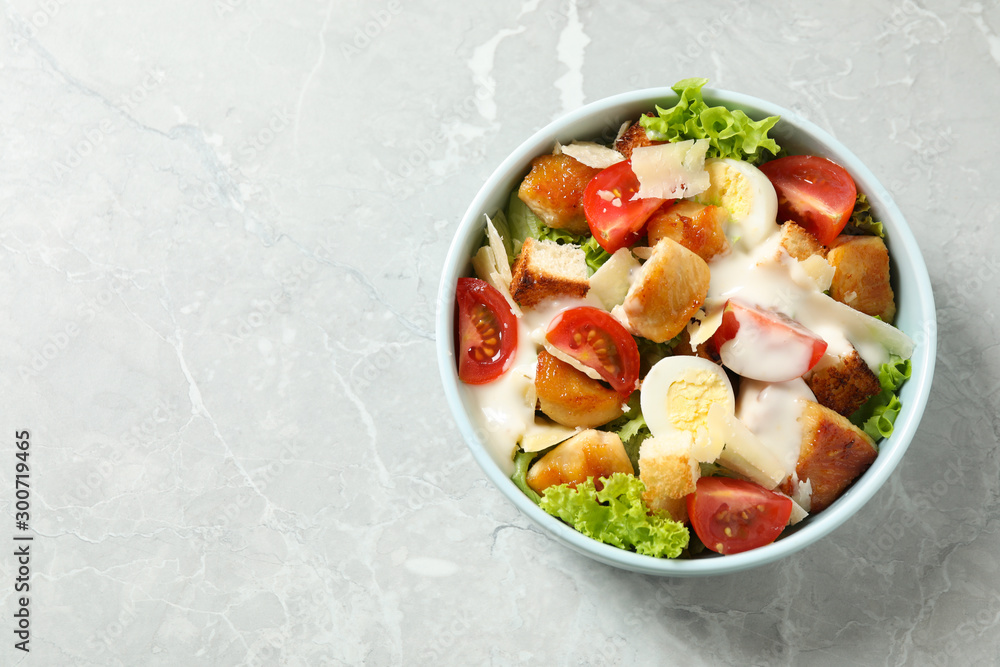 Delicious fresh Caesar salad on grey marble table, top view. Space for text Delicious fresh Caesar salad on grey marble table, top view. Space for text