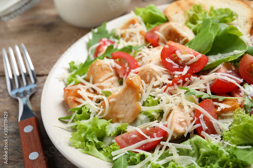 Delicious fresh Caesar salad on wooden table, closeup