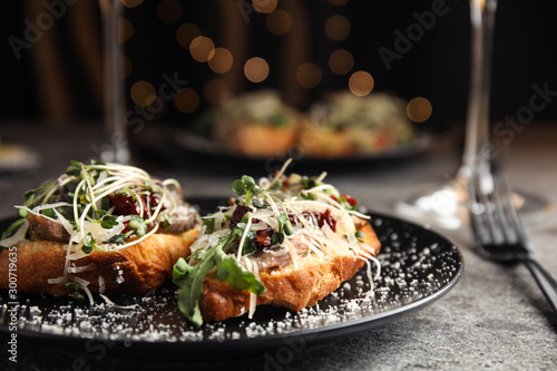 Delicious bruschettas with beef and cheese on grey table, closeup