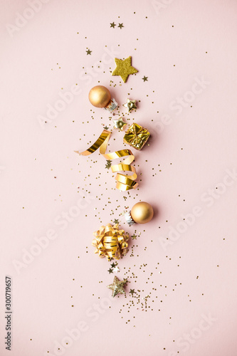 Flat lay of Celebration. Golden Christmas decorations on pink background