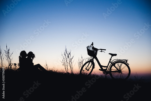 Silhouette of mother and baby biking at sunset © Konstantin