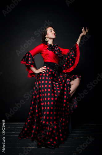 Carmen beautiful woman in red dress on dark background