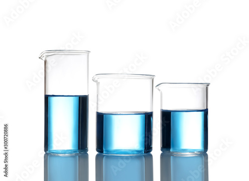 Beakers with blue liquid isolated on white. Laboratory glassware