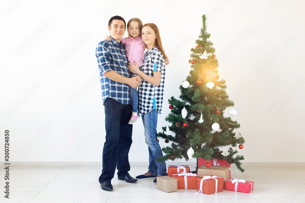 Holidays, gifts and christmas tree concept - Small family having happy time together on Christmas. Holidays, gifts and christmas tree concept - Small family having happy time together on Christmas.