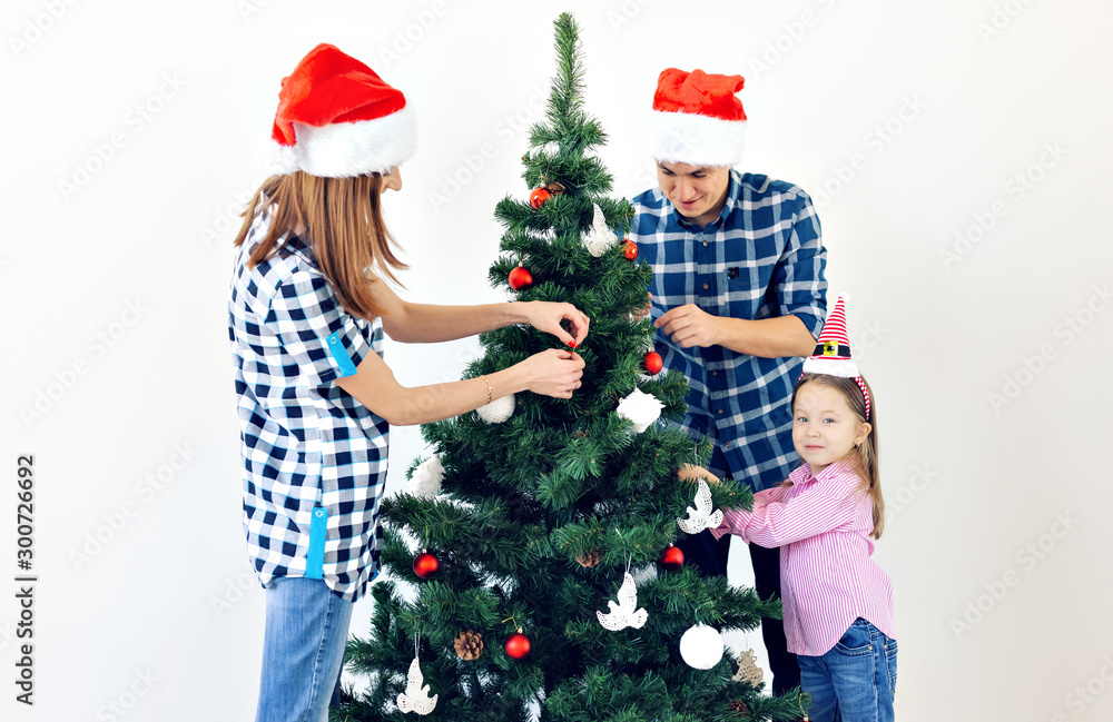 Holidays, x-mas and celebrating concept - Happy family decorating Christmas tree in holiday on white background Holidays, x-mas and celebrating concept - Happy family decorating Christmas tree in holiday on white background