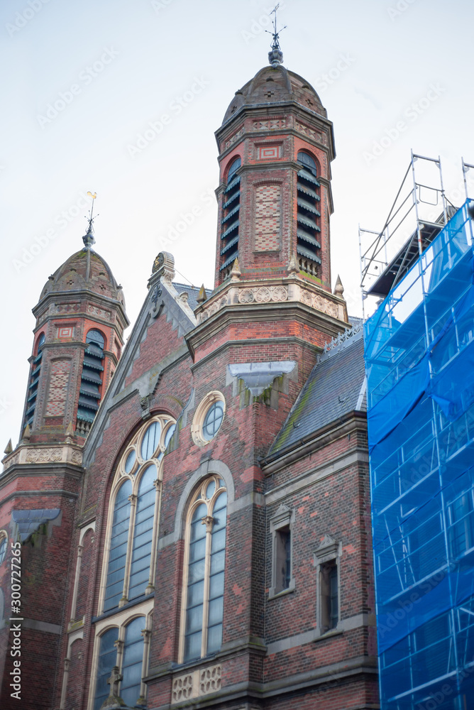Obraz premium Old red brick Church in Hoorn and construction site covered with blue cover, North Holland, Netherlands
