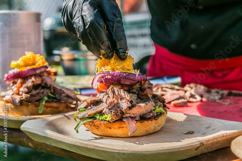 Close up hands of chef preparing fresh burger . Cooking concept