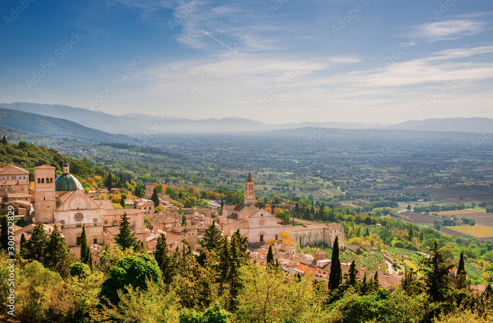 View of Assisi charming historic center and Umbria countryside seen from Rufinus Hill with haze in the background