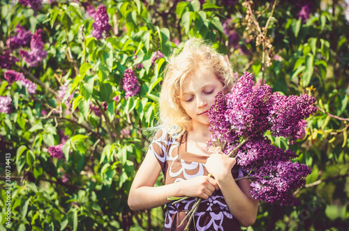 charming caucasian child with lilac bouquet in hands