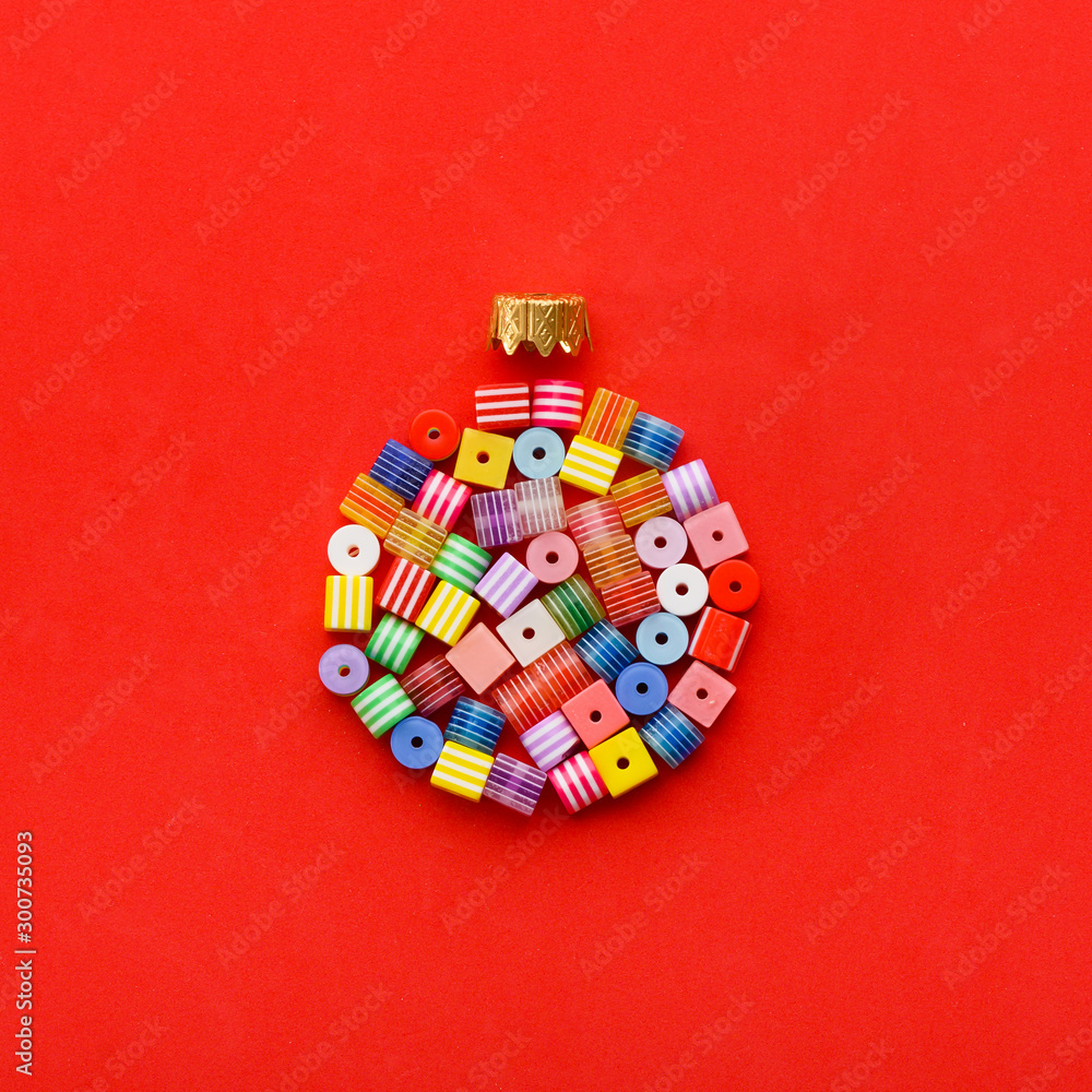 Christmas Bauble made of decoration elements on red background. Flat lay. Contemporary design. Contemporary art. Creative conceptual and colorful collage.