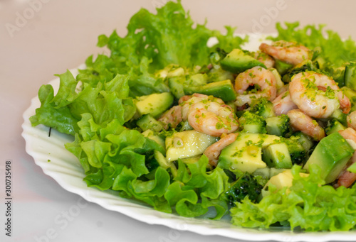 fresh salad with avocado and shrimp on a plate macro