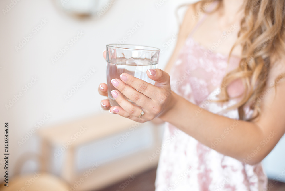 Female hands holding a clear glass of water. Slime body on background. Healthy lifestyle. Female hands holding a clear glass of water. Slime body on background. Healthy lifestyle.