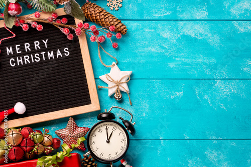 Letter board with words Merry Christmas, vintage clock and decorations on blue wooden table. Winter Christmas celebration concept. Free space for your text photo