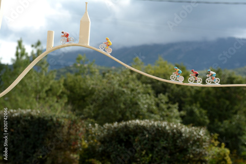 Representation in forged iron of the Mont Ventoux with racing cyclists. In the background the real cloudy Ventoux mountain. Autumn in France, Provence, Vaucluse. photo