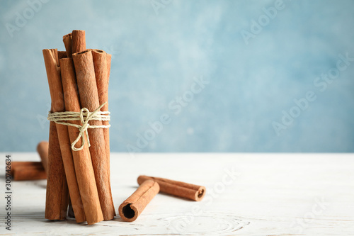 Canvastavla Cinnamon sticks on white wooden background, space for text