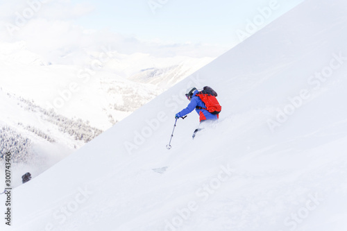 Photo from back of sports man with backpack skiing