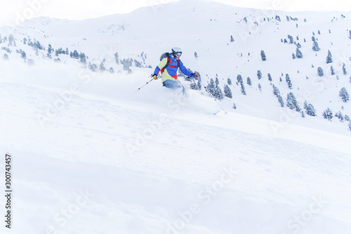 Photo of sports man in mask and helmet skiing in winter resort