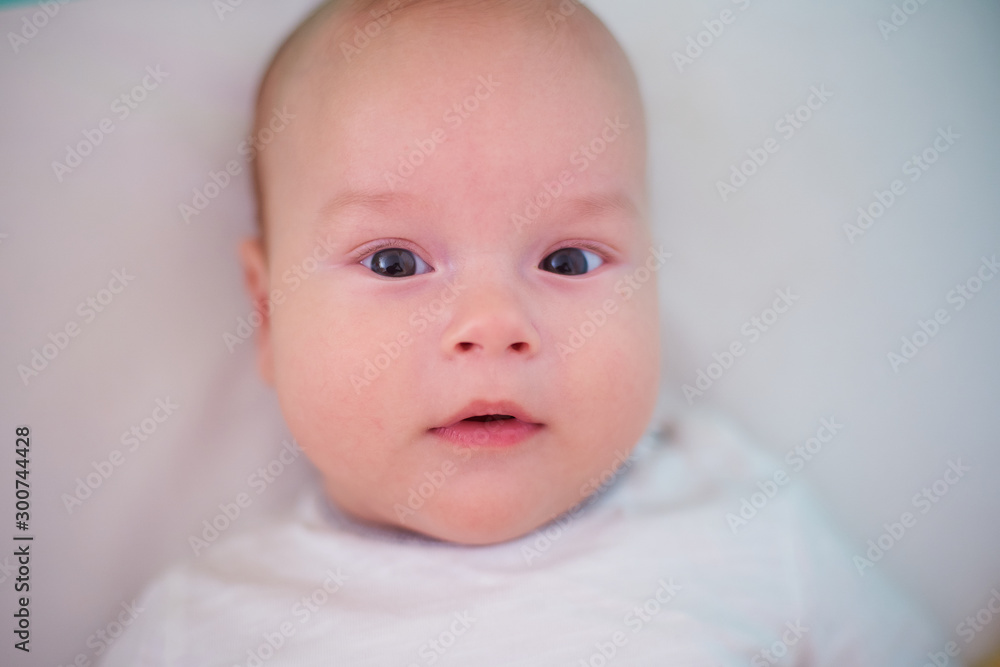 Portrait of a baby on the bed, kid looking at the camera